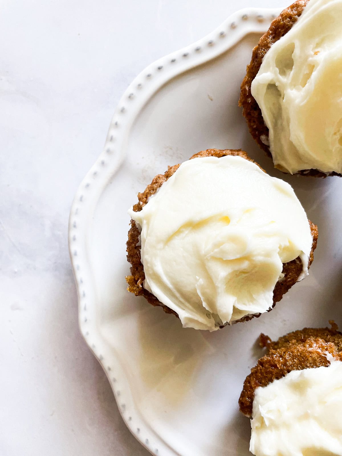 A carrot cake cupcake on a plate.