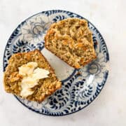 A gluten free carrot muffin cut in half, one half with butter.