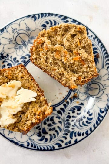 A gluten free carrot muffin cut in half, one half with butter.