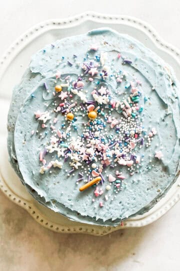 A gluten free unicorn cake topped with sprinkles.