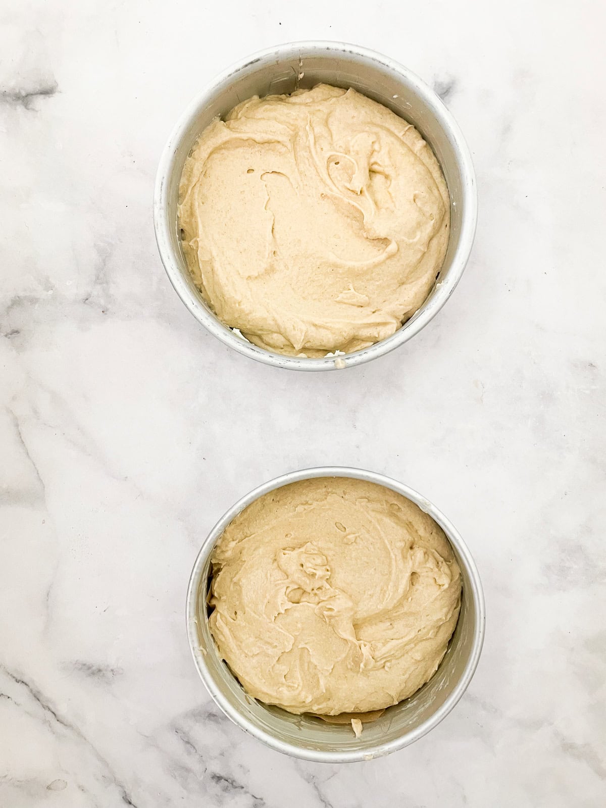 Buttermilk cake batter added to cake pans.