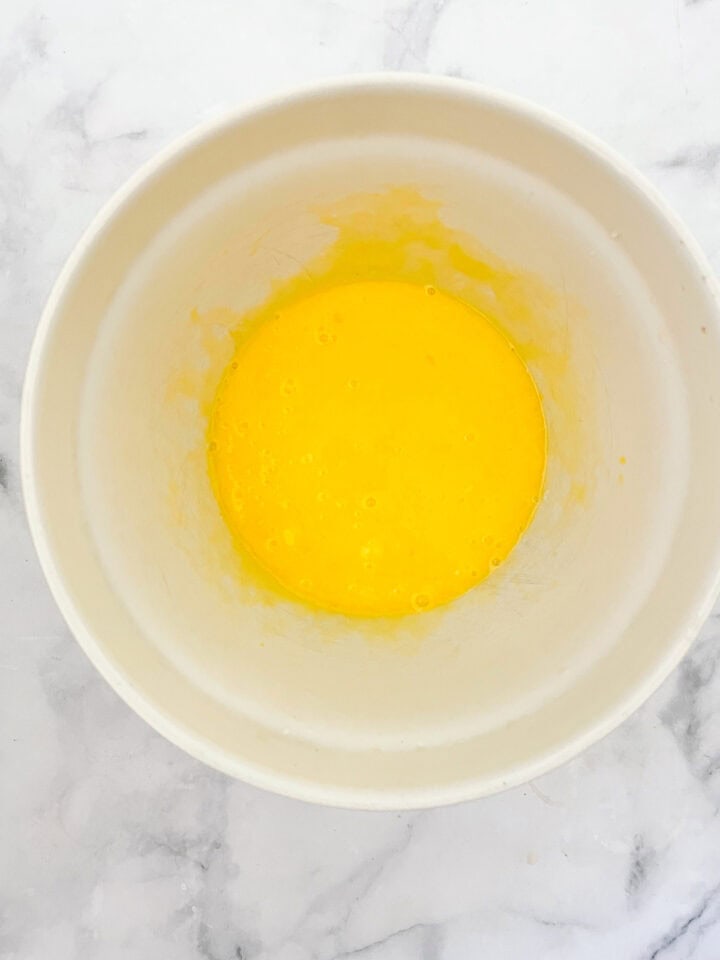 Eggs are mixed with oil in a bowl.