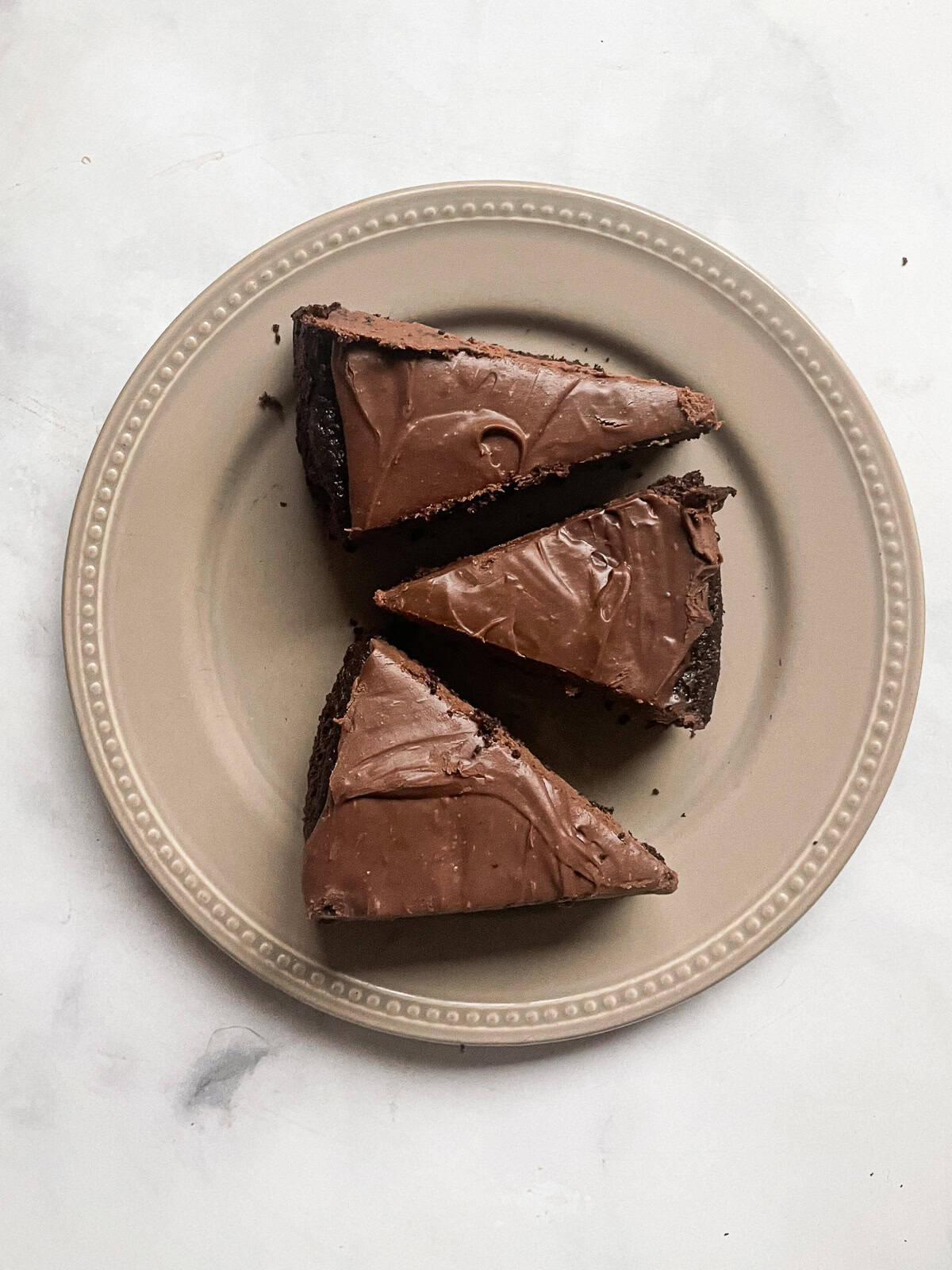 Three slices of chocolate teff cake on a plate.
