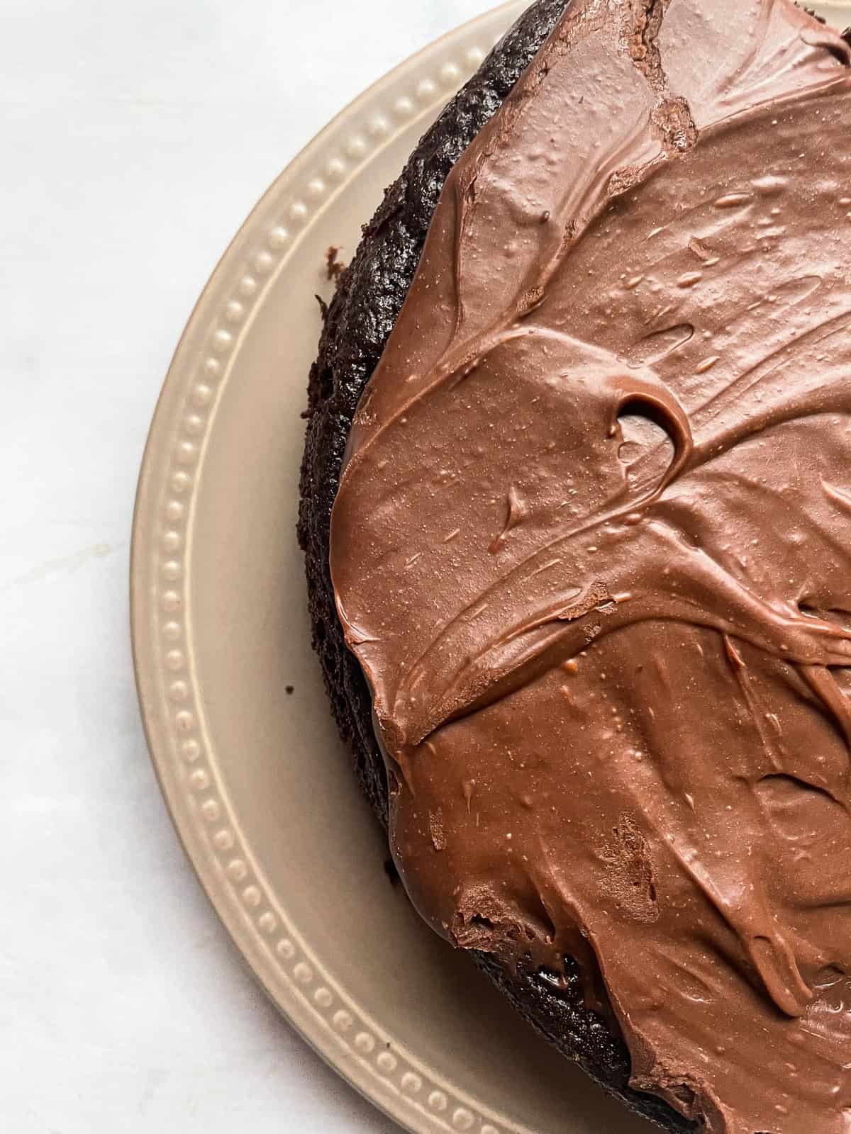Part of a chocolate teff cake with chocolate frosting.