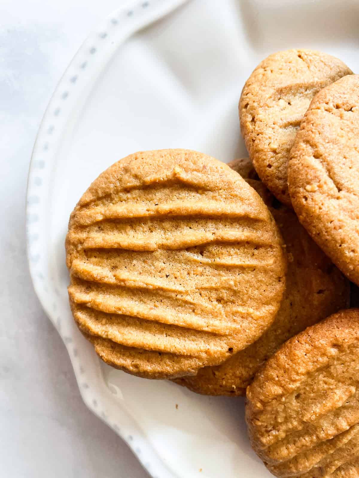 A gluten free peanut butter cookie on a white plate.