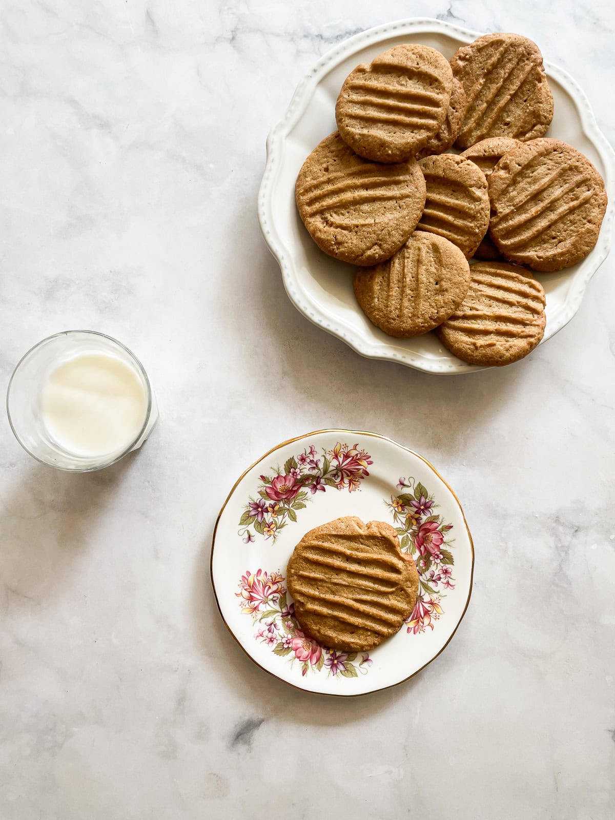 Tender and super peanut buttery gluten-free peanut butter cookies are made in just one bowl! Packed with sweet-salty flavor in every bite. A plate of gluten-free peanut butter cookies and a cookie on a plate.