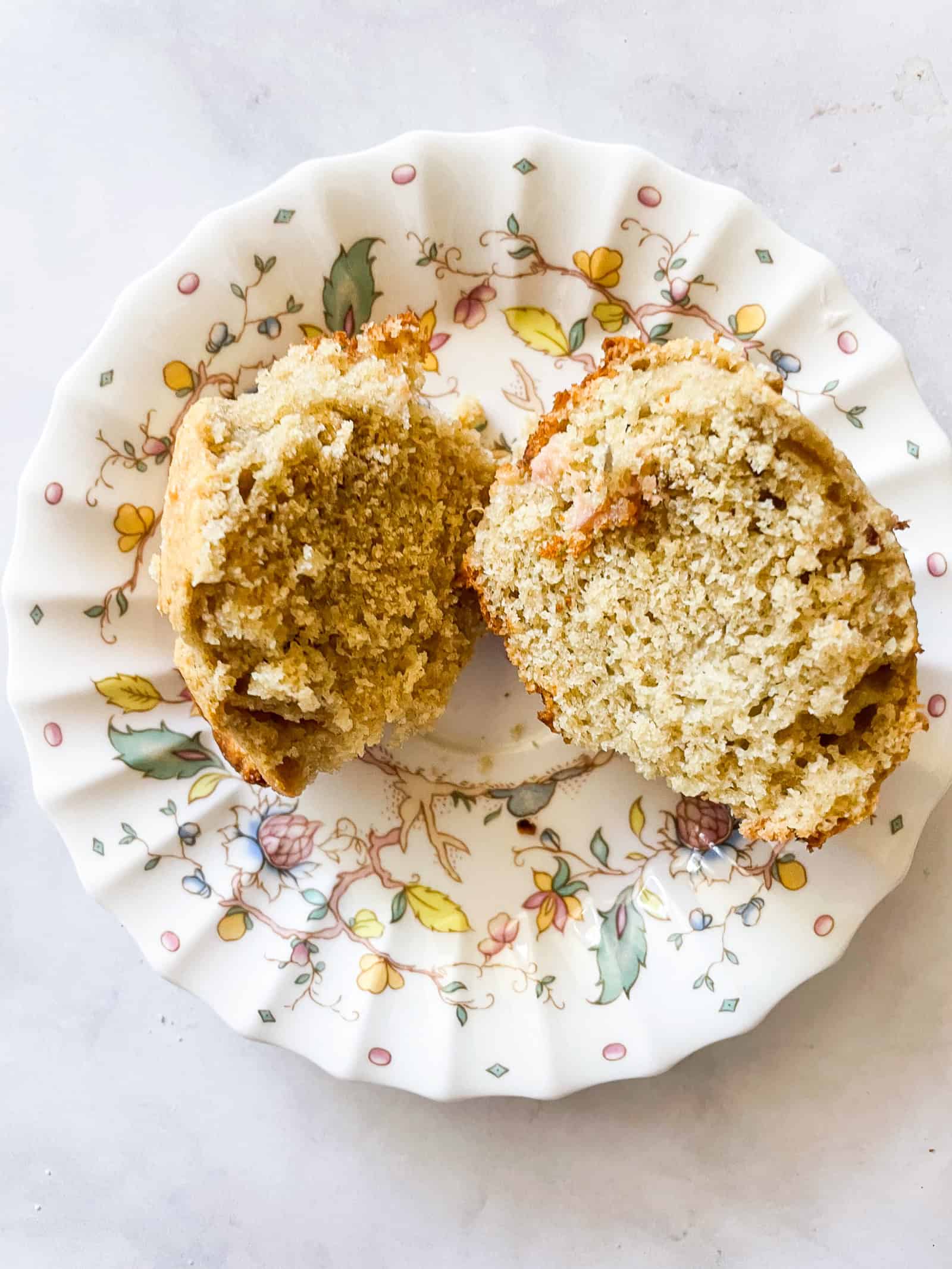 Tender and wholesome gluten free rhubarb muffins make great use of seasonal rhubarb. Oat and almond flours star in this easy recipe. A gluten free muffin cut in half on a plate.