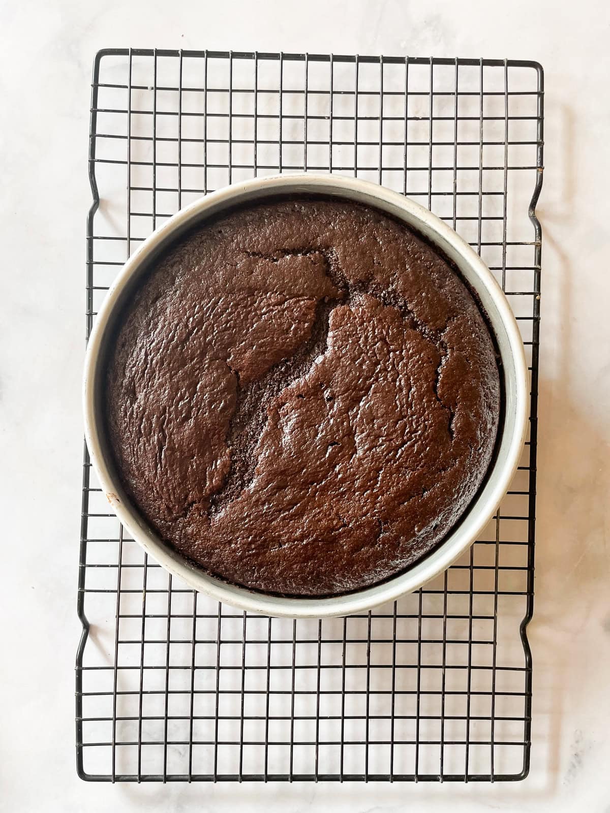A chocolate teff cake cools in a baking pan.