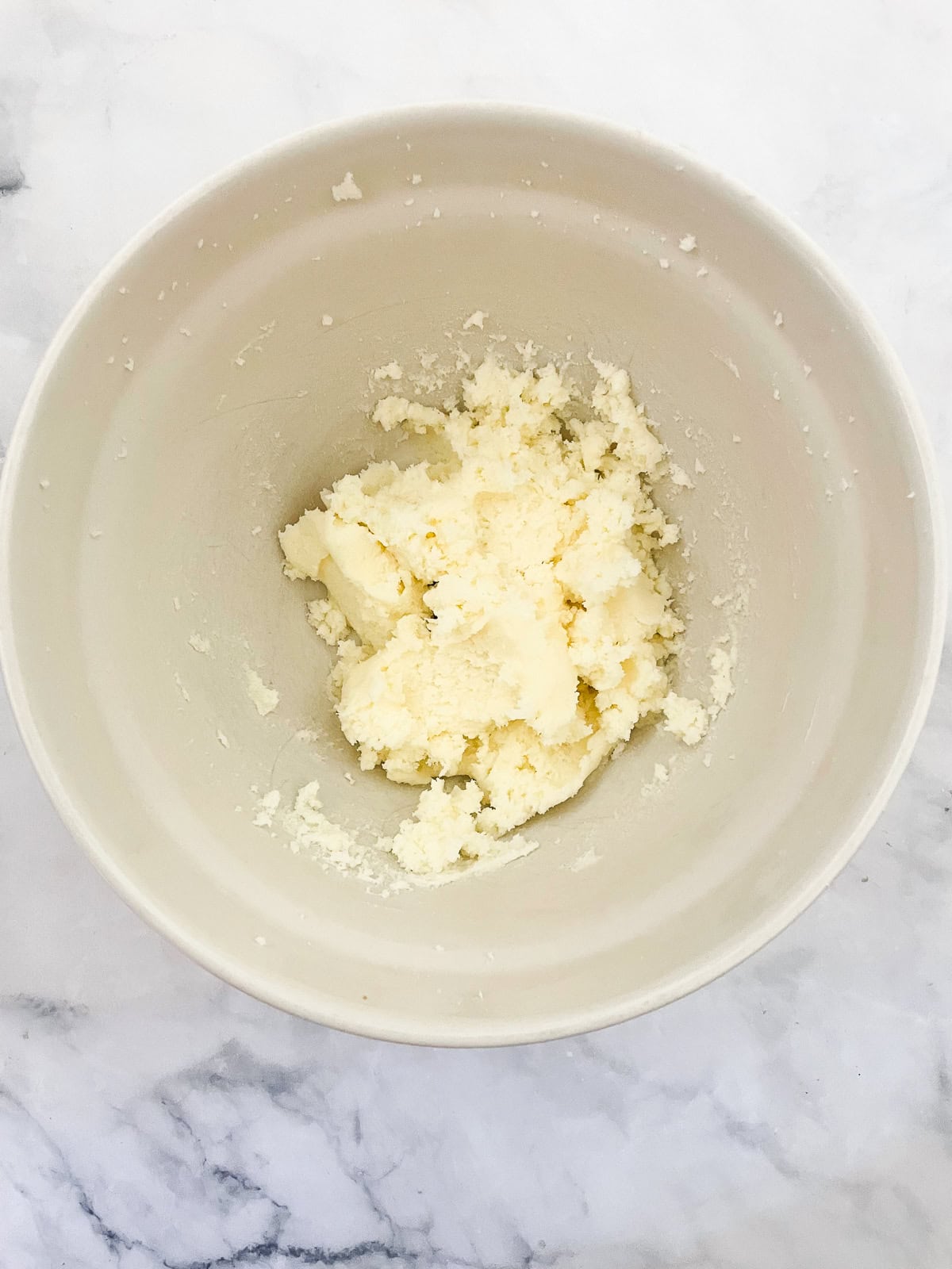 This beautiful gluten-free birthday cake recipe features velvety vanilla cake layers filled and frosted with chocolate buttercream frosting Butter and sugar creamed in a bowl.