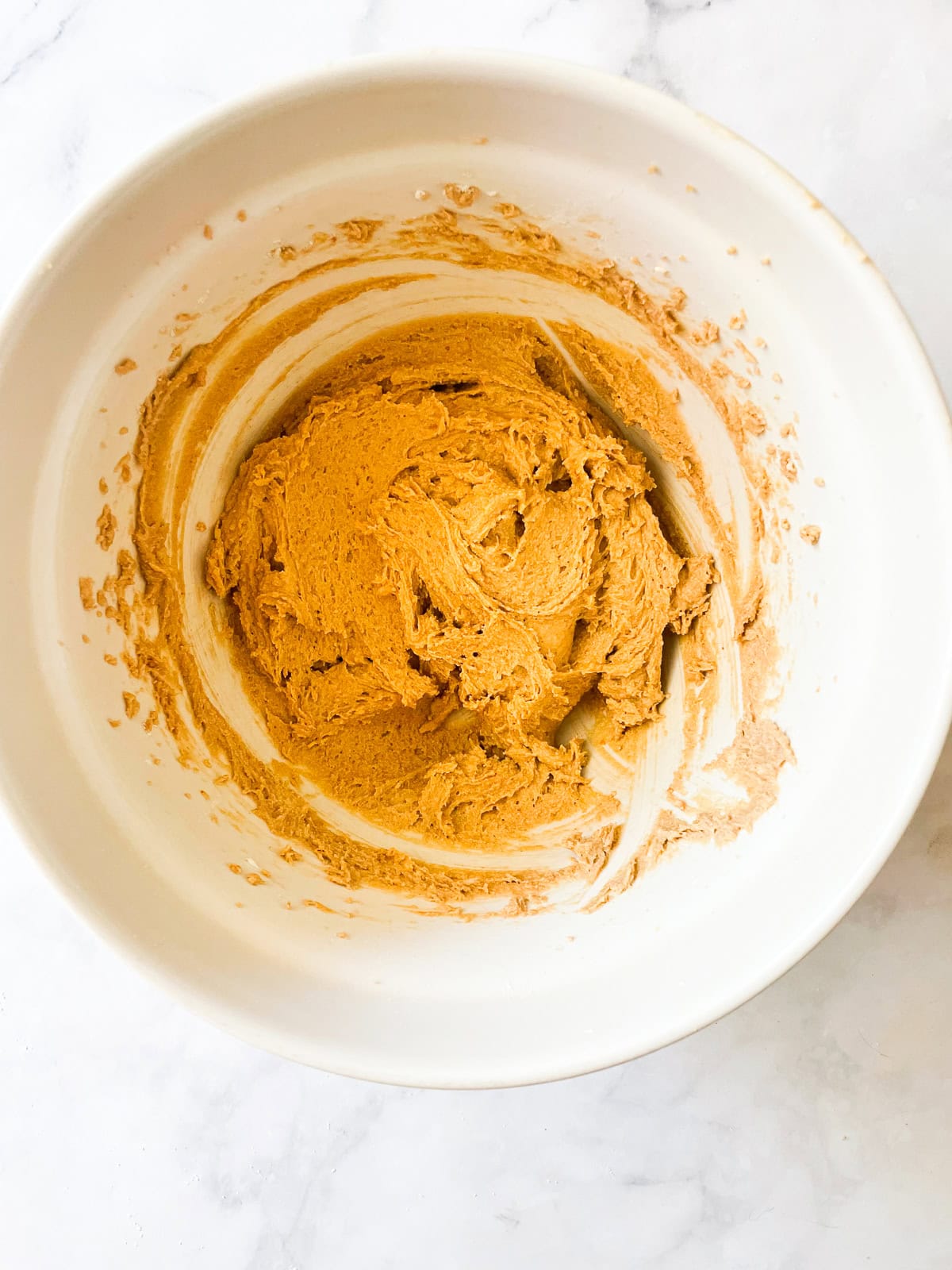 Tender and super peanut buttery gluten-free peanut butter cookies are made in just one bowl! Packed with sweet-salty flavor in every bite. The dough for gluten-free peanut butter cookies mixed in a bowl.