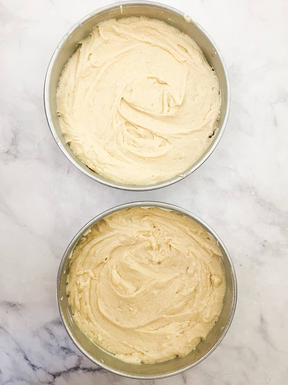 Cake batter added to 2 cake tins.