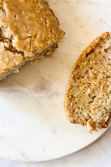 A loaf of gluten free coconut loaf cake with a slice cut from it.
