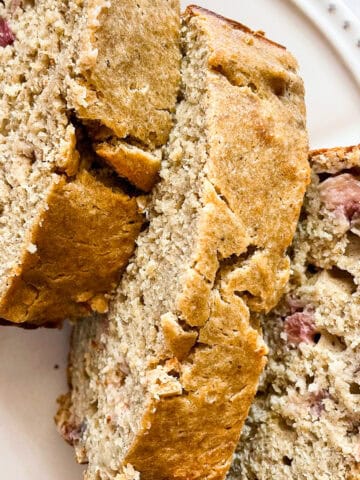 Three slices of gluten free rhubarb banana bread on a plate.