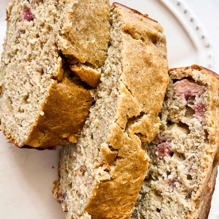 Three slices of gluten free rhubarb banana bread on a plate.