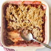 A pan of gluten-free rhubarb crisp with a spoon.