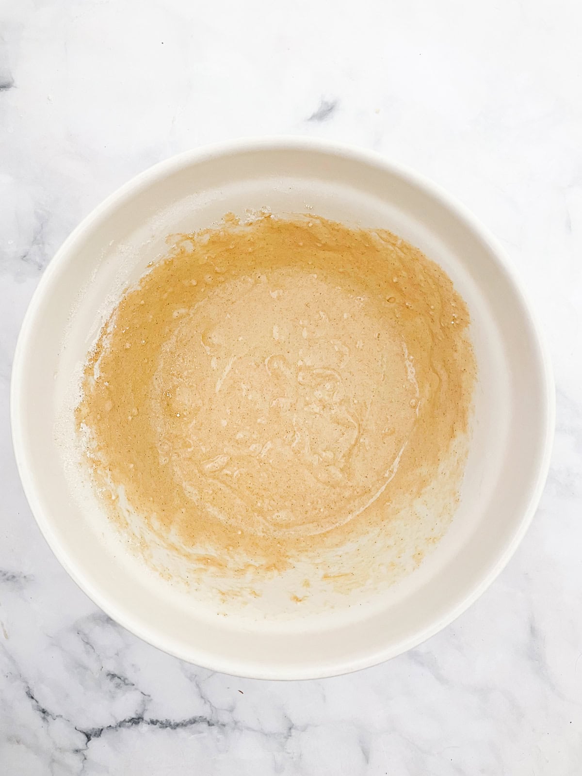 Wet and dry mix for gluten free strawberry muffins combined in a bowl.