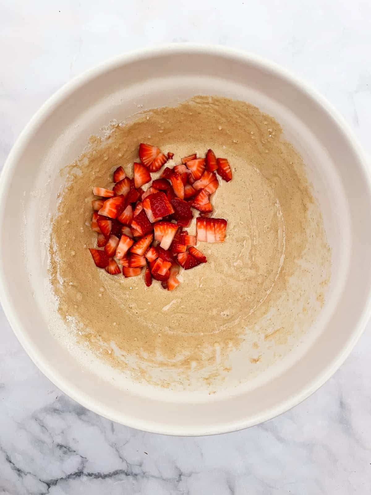 Strawberries are added to gluten free muffin batter.