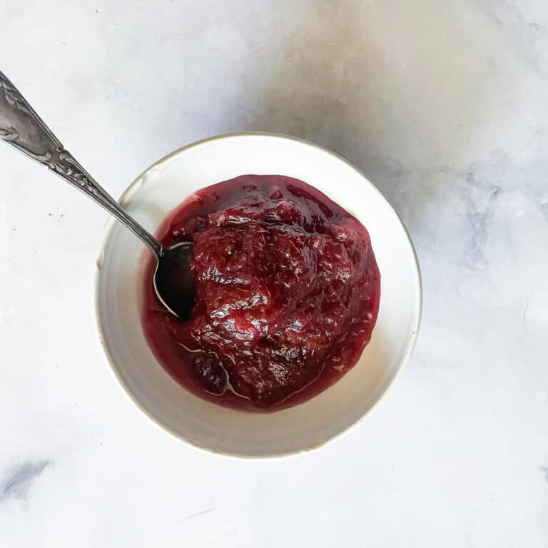 A bowl of rhubarb compote with a spoon.