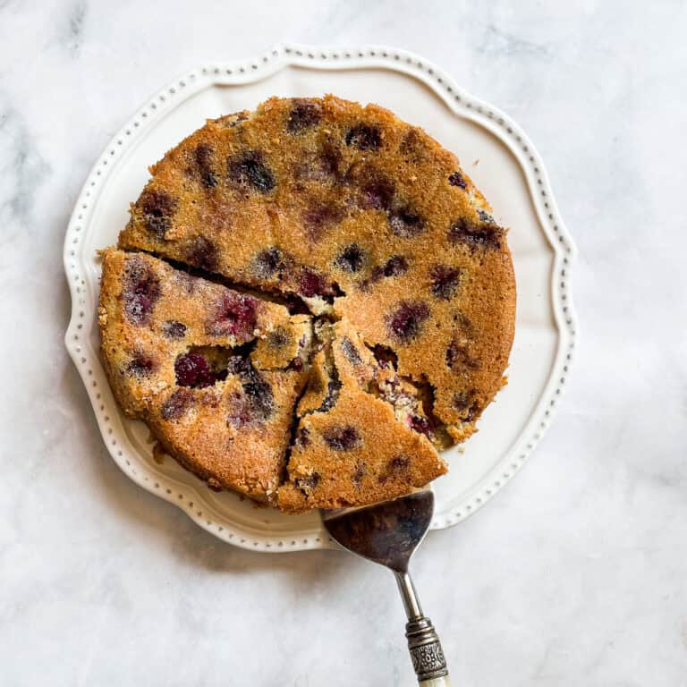 A cake server lifts out a piece of cherry torte.