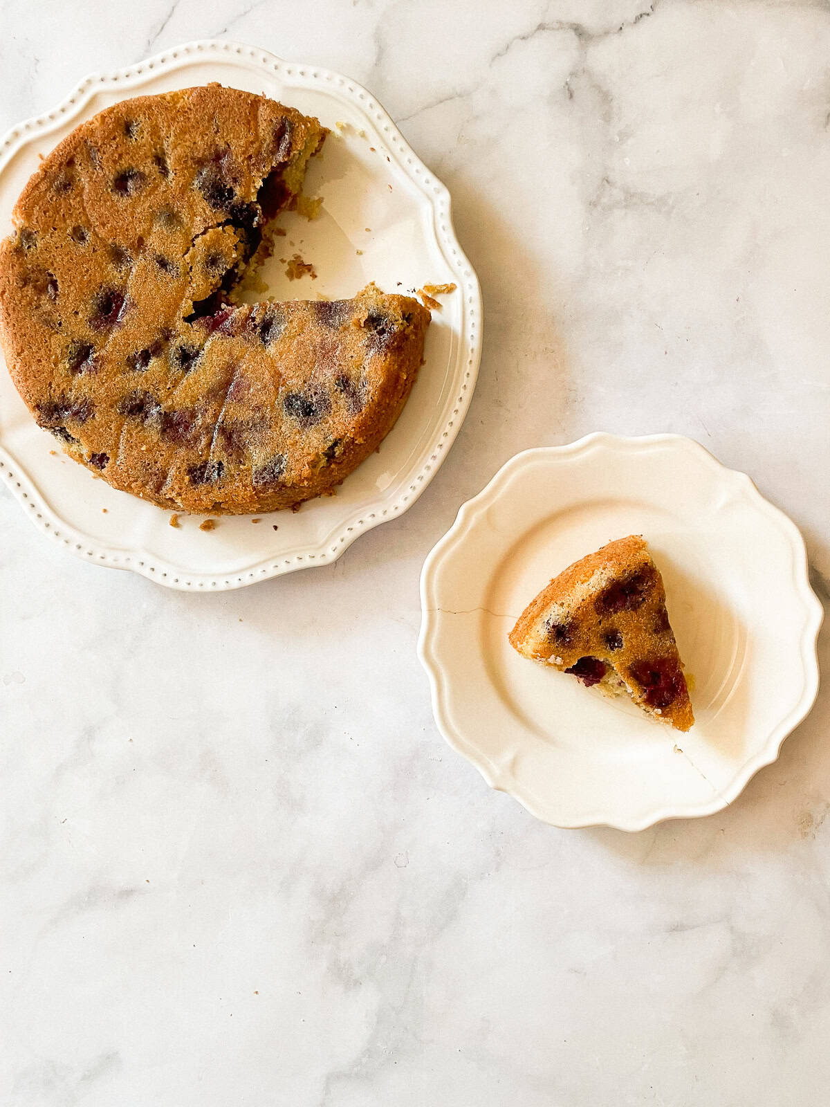 This rustic gluten-free cherry torte tucks sweet, fresh cherries into a tender, buttery cake made with just two simple gluten-free flours. A gluten free cherry torte on a plate and a slice of cake on a plate.