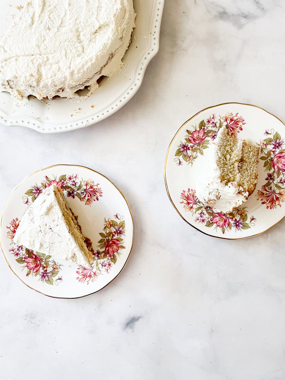 This beautiful gluten free rhubarb cream cake pairs buttery cake with a layer of sweet-tart rhubarb compote and a cloud of whipped cream. Slices of gluten free rhubarb cream cake on plates.