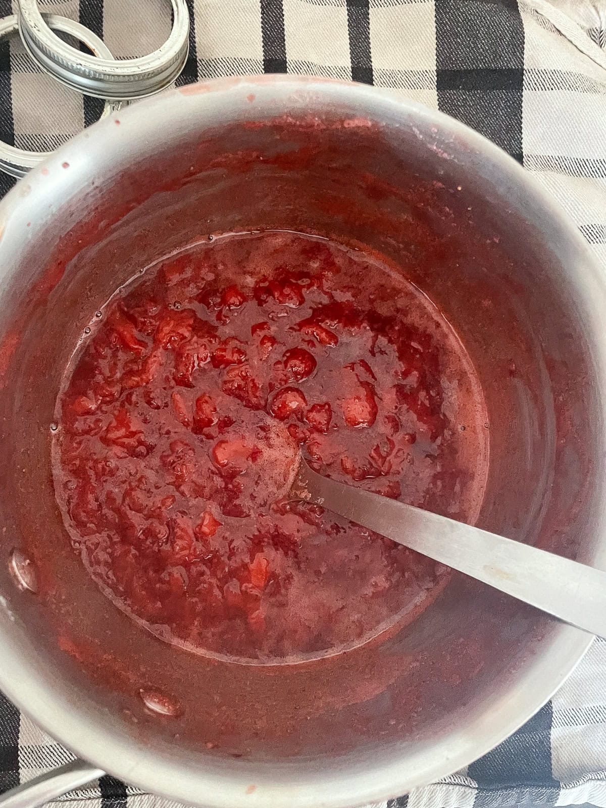 A recipe for a beautifully hued, low sugar strawberry jam that's also made without pectin. You can make this a refrigerator jam or can it. A pot of low sugar strawberry jam at the end of the cooking process.