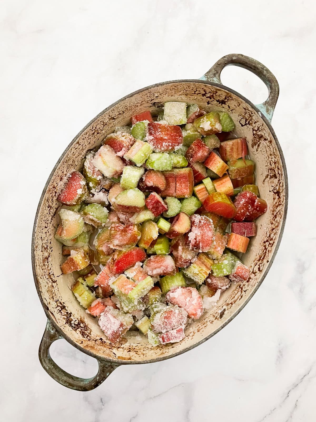 A pretty raspberry rhubarb jam that marries seasonal fresh berries with tart rhubarb to make a silky smooth, uniquely flavored jam. Adding sugar to raspberries and rhubarb for jam.