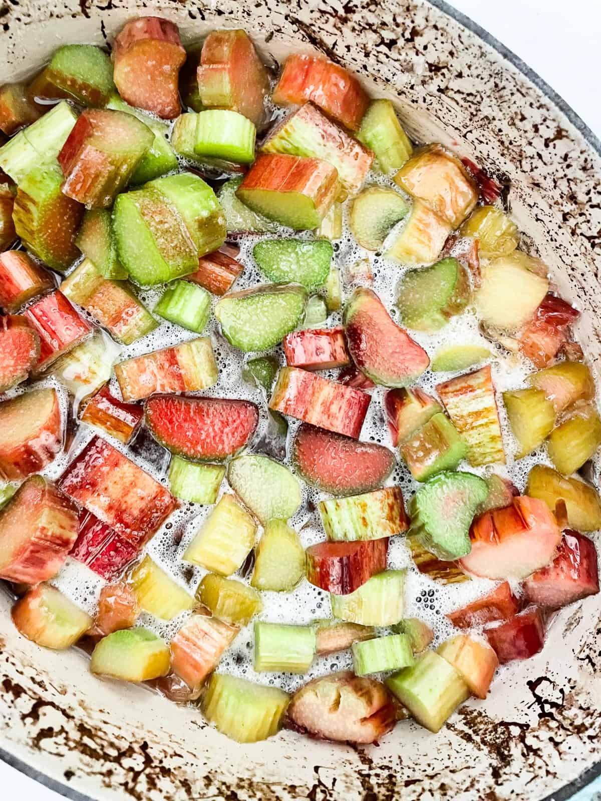 Ingredients for strawberry rhubarb jam mixed in a pot.