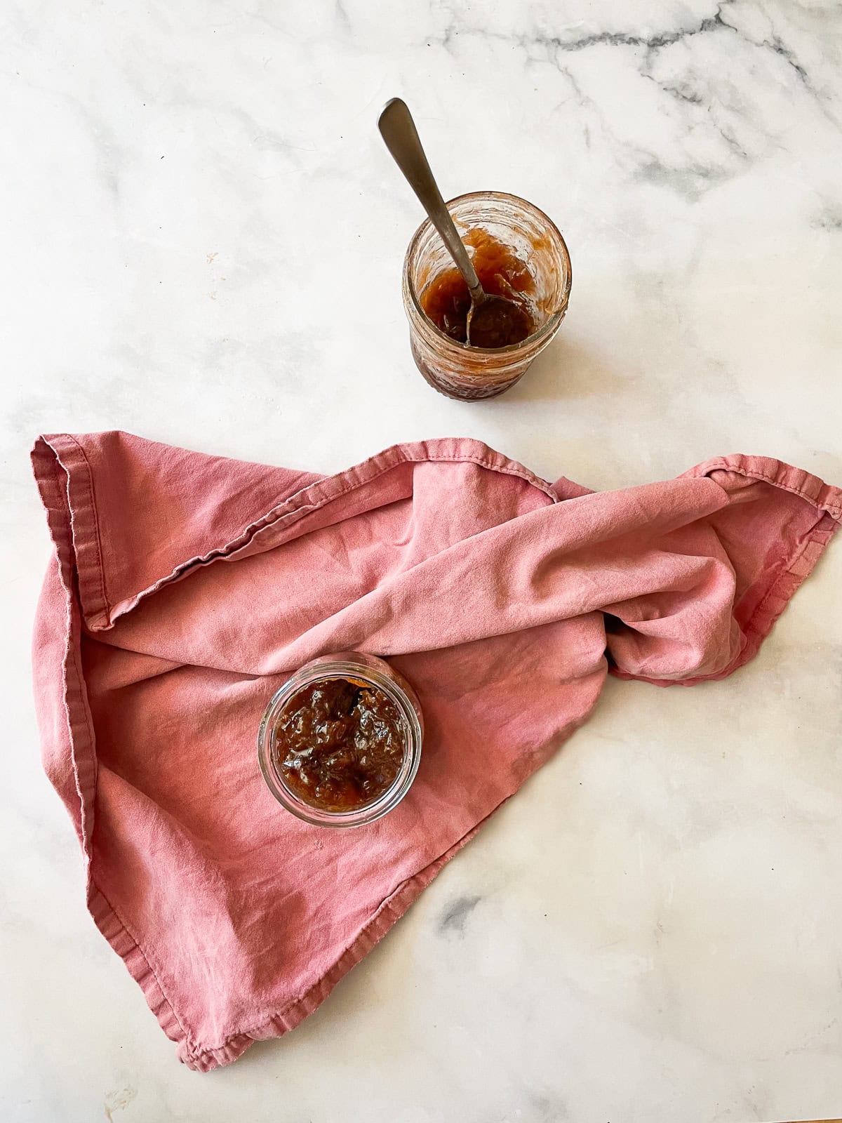 Jars of strawberry & rhubarb jam and a red napkin.