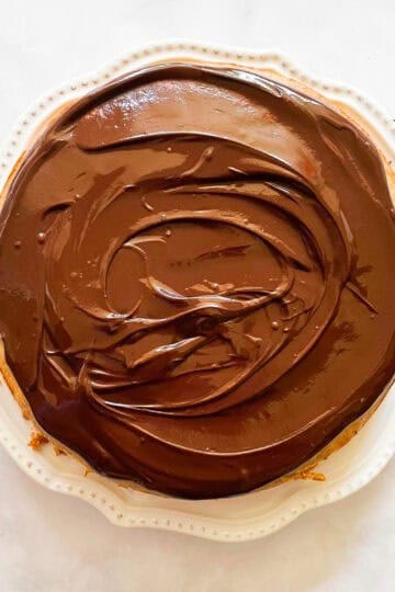 A banana cake with chocolate frosting on a plate.
