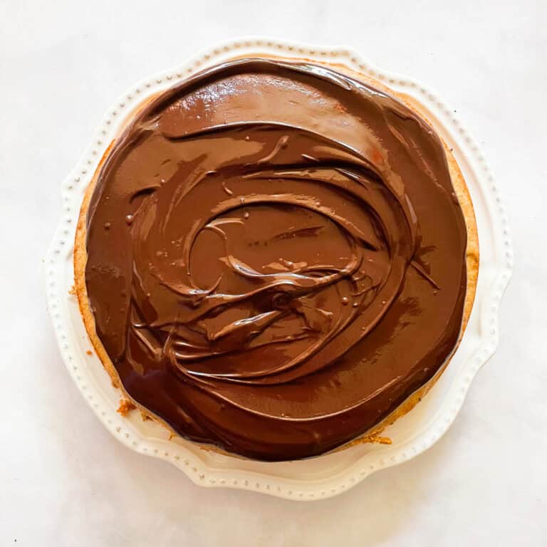 A banana cake with chocolate frosting on a plate.