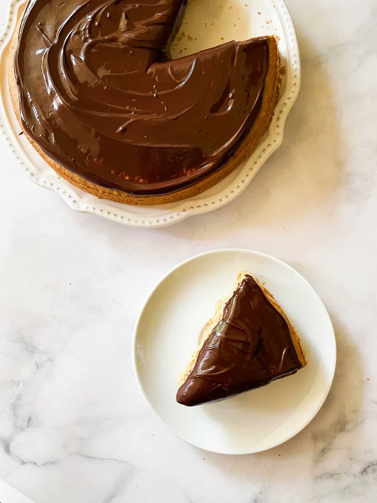 A lusciously moist, spice-kissed banana cake with chocolate frosting is the simplest recipe that always manages to impress! A slice of banana bake on a plate.