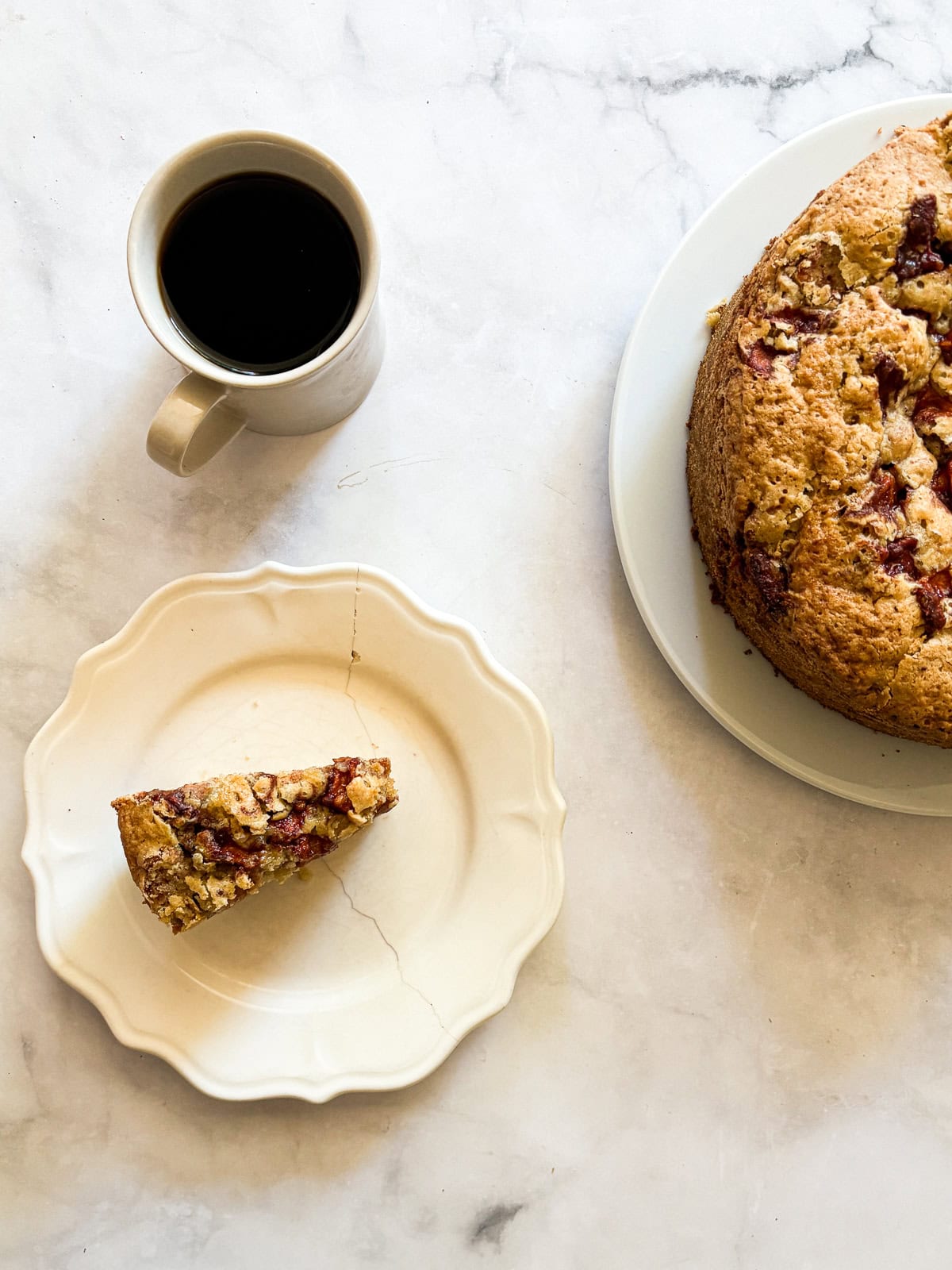 A sweet and simple gluten free apple cake that showcases a tender cake layered with cinnamon-y apples. One-bowl recipe! A slice of gluten free apple cake, cup of coffee, and the cake.