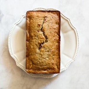A loaf of easy banana strawberry bread on a white plate.