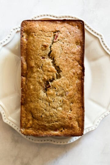 A loaf of easy banana strawberry bread on a white plate.