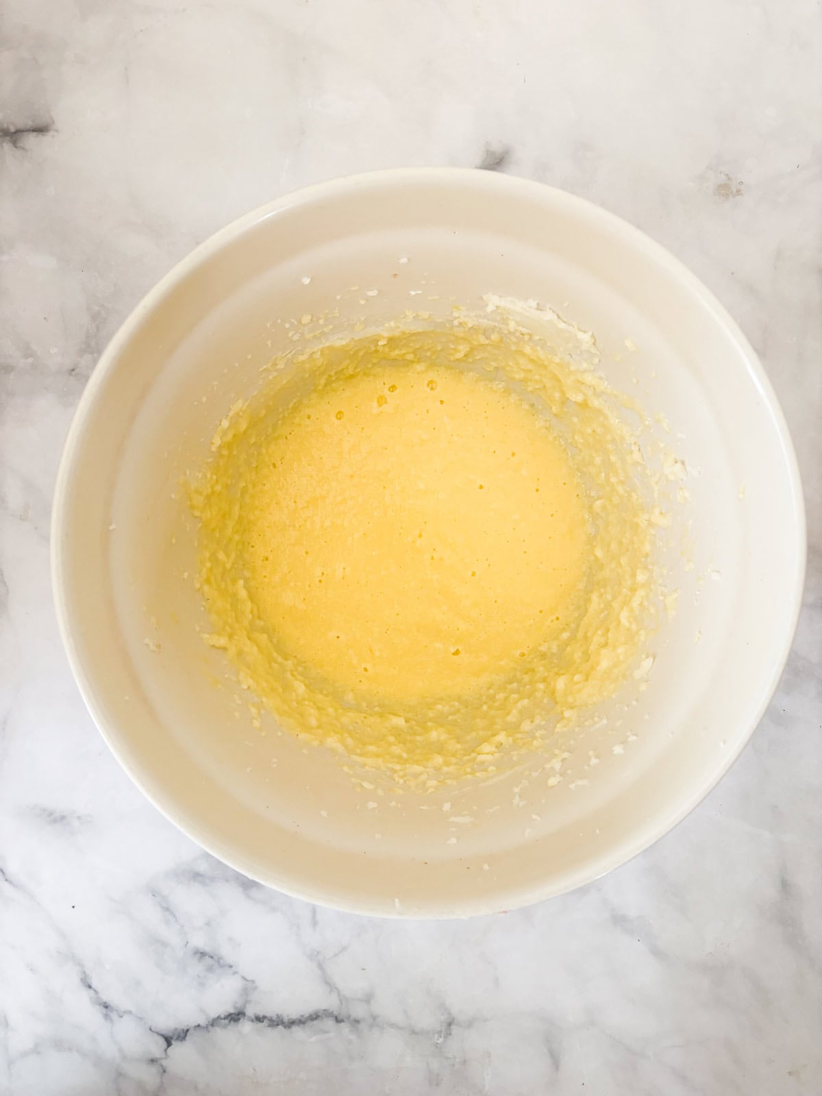 This buttery and tender gluten free French apple cake is inspired by a classic recipe and will almost literally melt in your mouth. Butter, sugar, eggs, bourbon and vanilla mixed in a bowl.