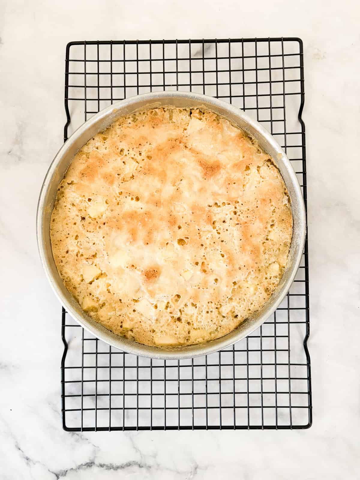 This buttery and tender gluten free French apple cake is inspired by a classic recipe and will almost literally melt in your mouth. A gluten free french apple cake cools in the pan on a rack.