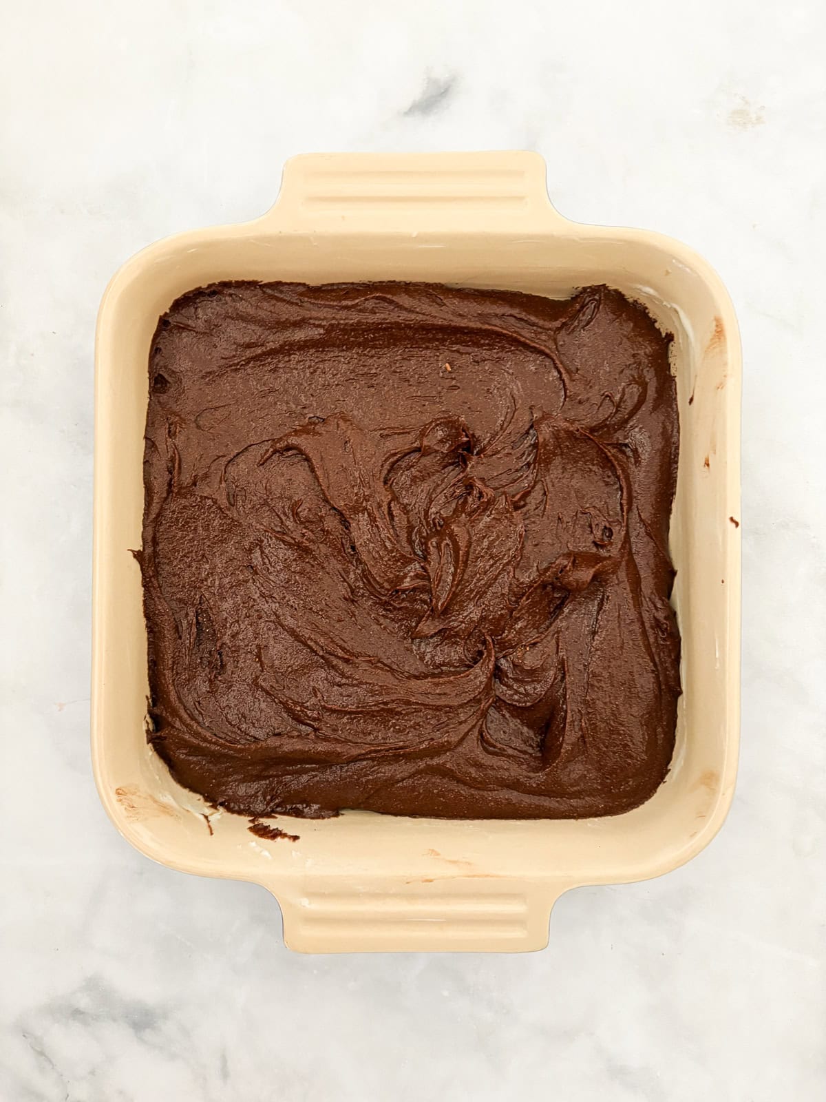 Effortless and gluten-free one bowl brownies are made in, yep, just one bowl. Just mix, pour, and bake to brownie perfection. Batter for gluten free one bowl brownies in a pan.