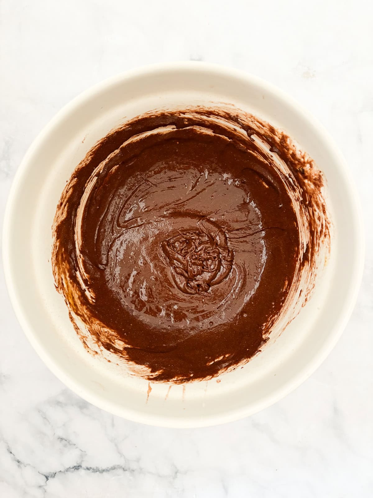 Effortless and gluten-free one bowl brownies are made in, yep, just one bowl. Just mix, pour, and bake to brownie perfection. The combined batter for one bowl brownies in a big bowl.