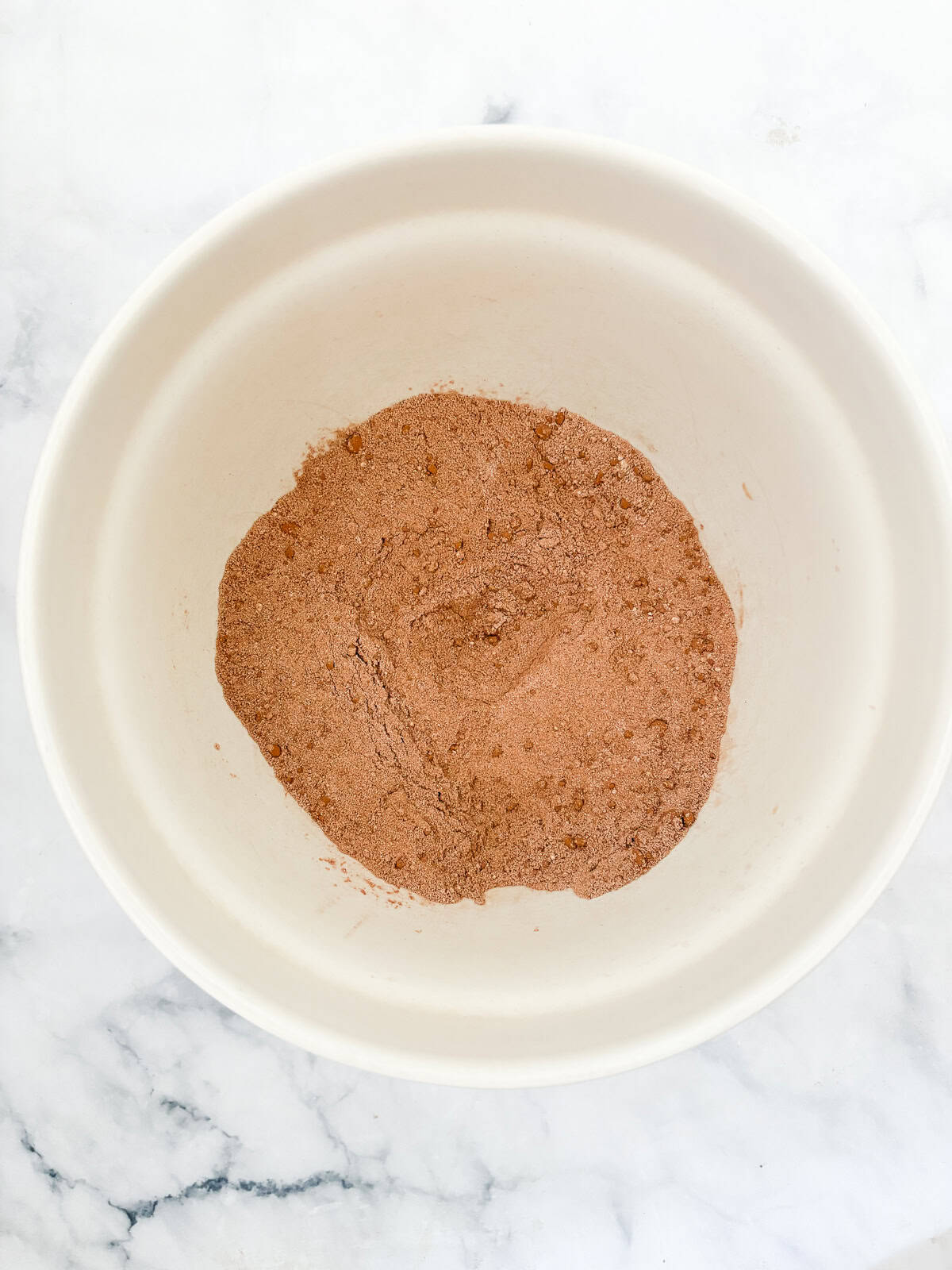 Effortless and gluten-free one bowl brownies are made in, yep, just one bowl. Just mix, pour, and bake to brownie perfection. Dry ingredients for one bowl brownies in a bowl.