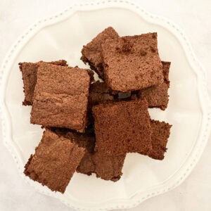 A nice pile of one bowl brownies served on a white plate.