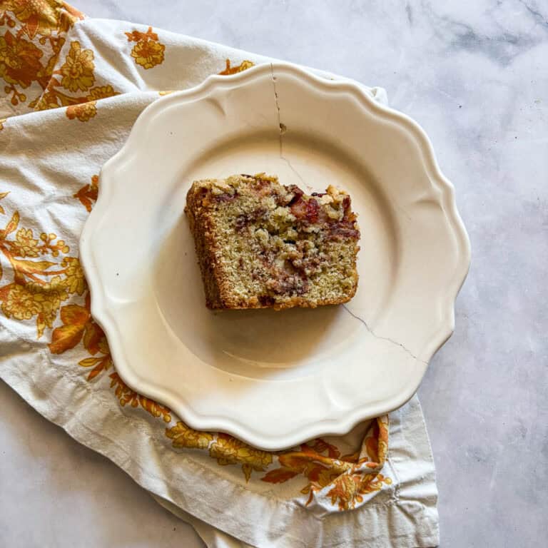 A thick slice of gluten free pear cake on its side on a plate.
