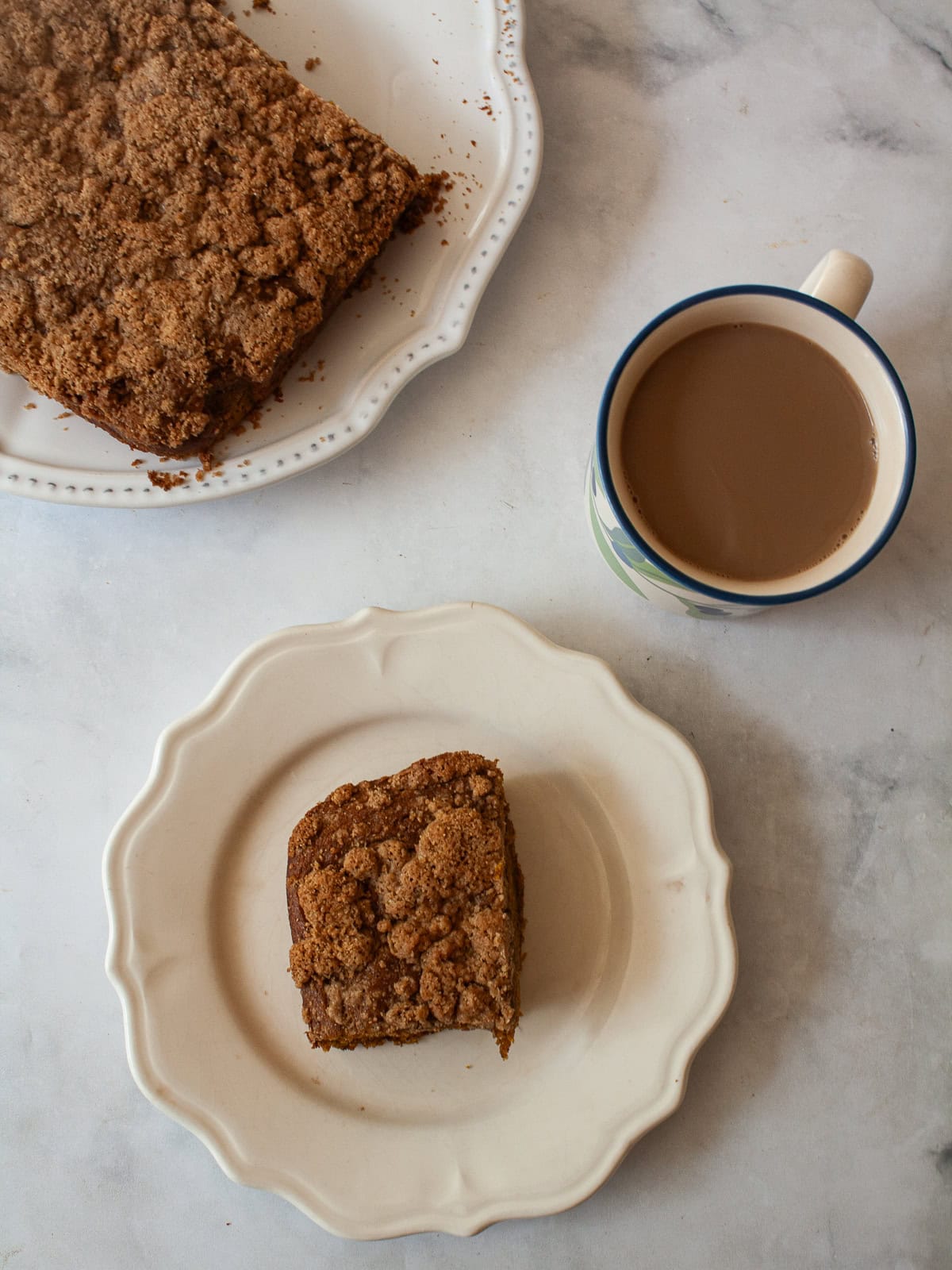 The perfect fall treat, this sweetly spiced and tender gluten free pumpkin coffee cake is topped with a delicious brown sugar streusel. A gluten free pumpkin coffee cake, a slice of cake, and a cup of coffee.