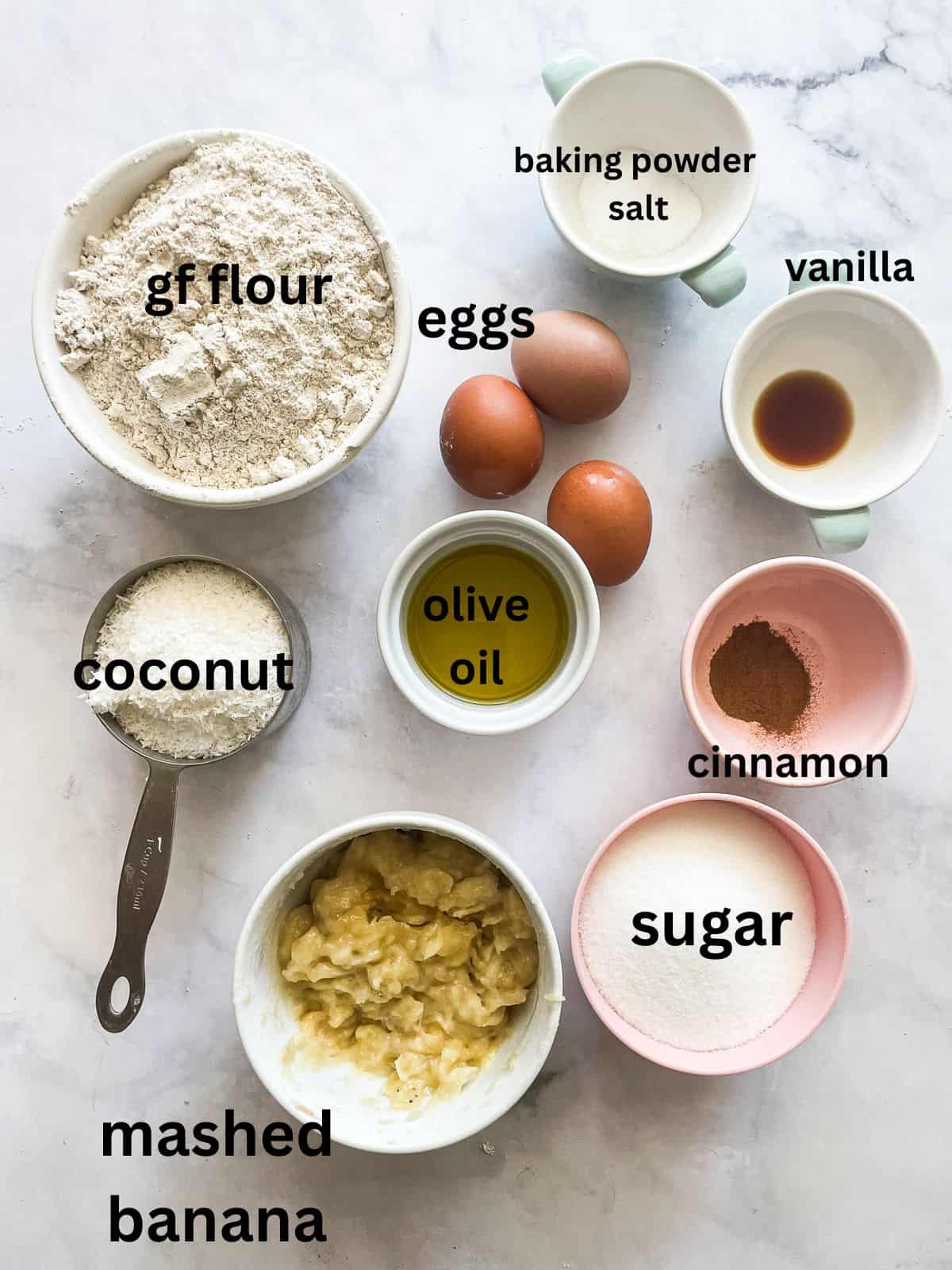 This recipe for gluten free coconut banana bread produces a beautiful loaf with a dense, moist crumb that's swirled with shredded coconut. Ingredients for gluten free coconut banana bread are text-labeled and portioned.