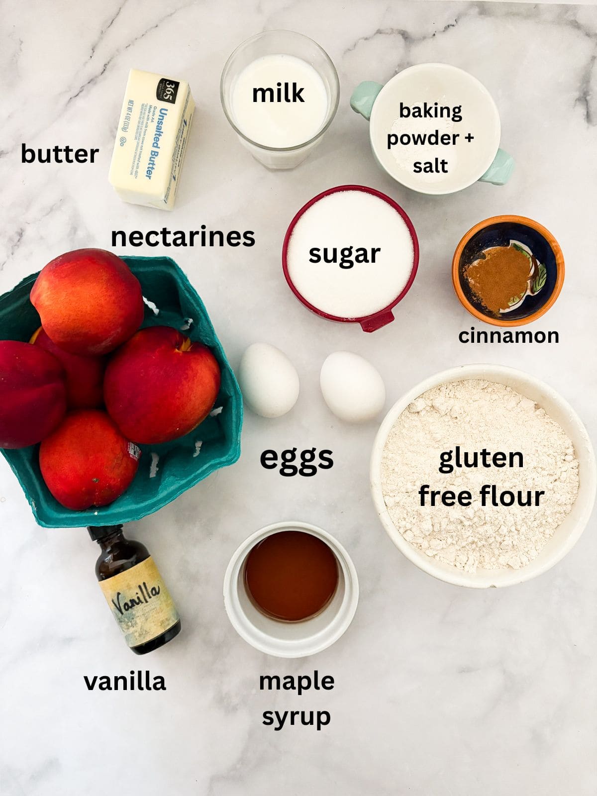 This gluten free nectarine cake is as pretty as it is delicious! Juicy sliced nectarines top a soft and sweet vanilla cake. Ingredients for a gluten free nectarine cake are text-labeled.