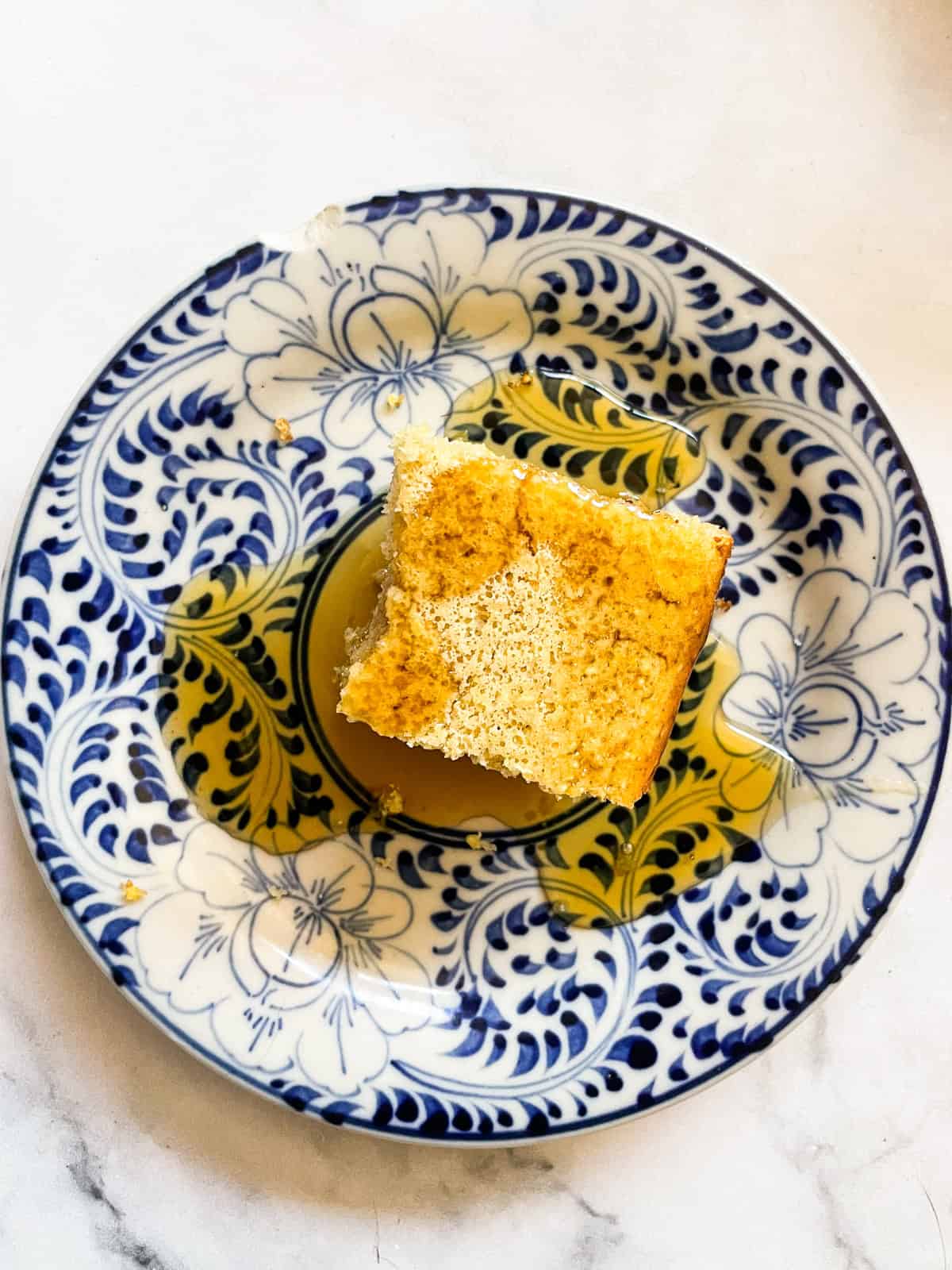Easy, gluten-free almond flour cornbread is made with a combo of almond flour and cornmeal. Wonderful with soups, stews, chili, and more. A square of almond flour cornbread on a blue and white plate.