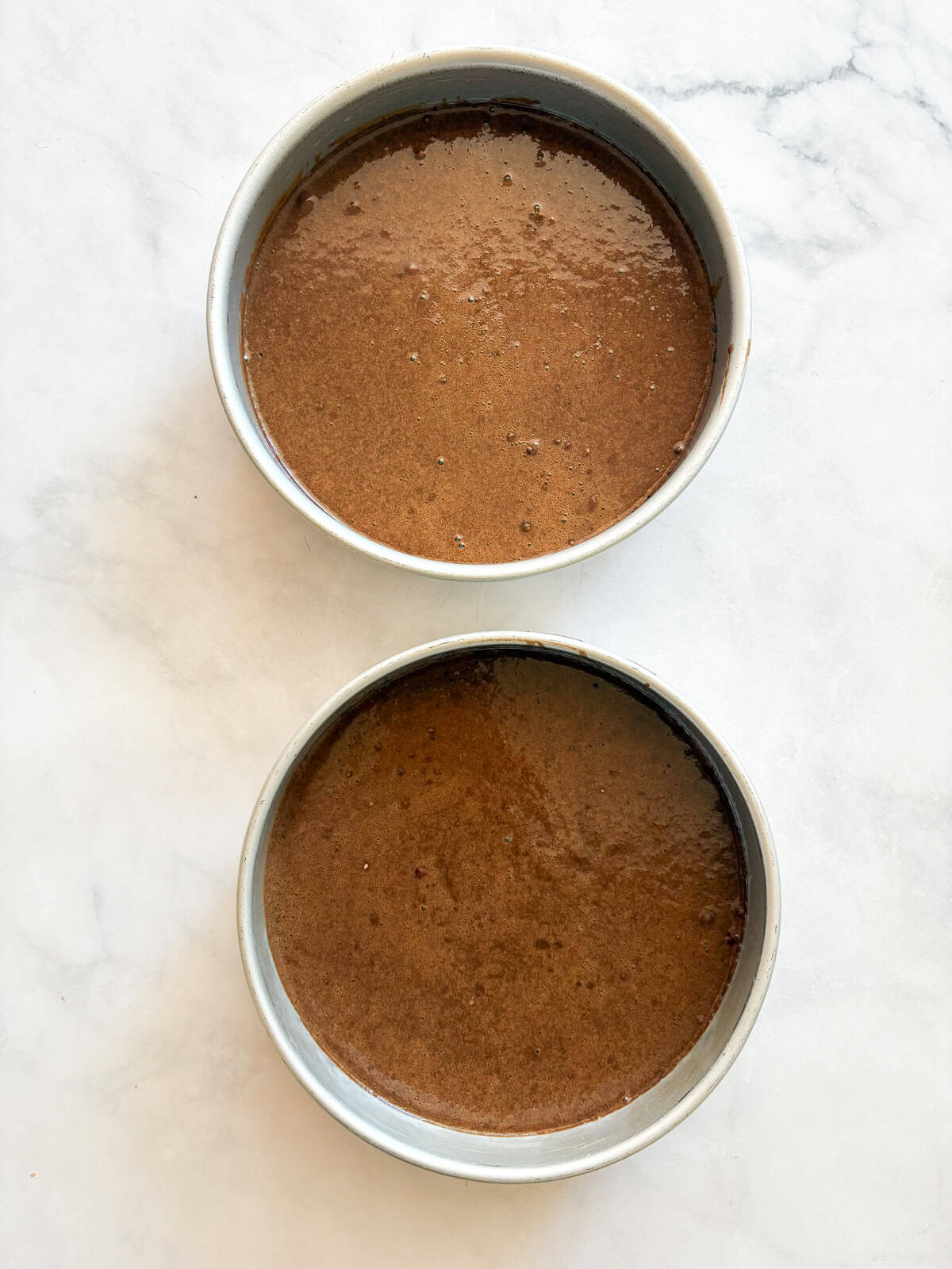 This is the best chocolate cake: Moist, tender, and with a perfect gluten-free crumb! Top it with chocolate buttercream for a real treat. Chocolate cake batter in 2 cake pans.