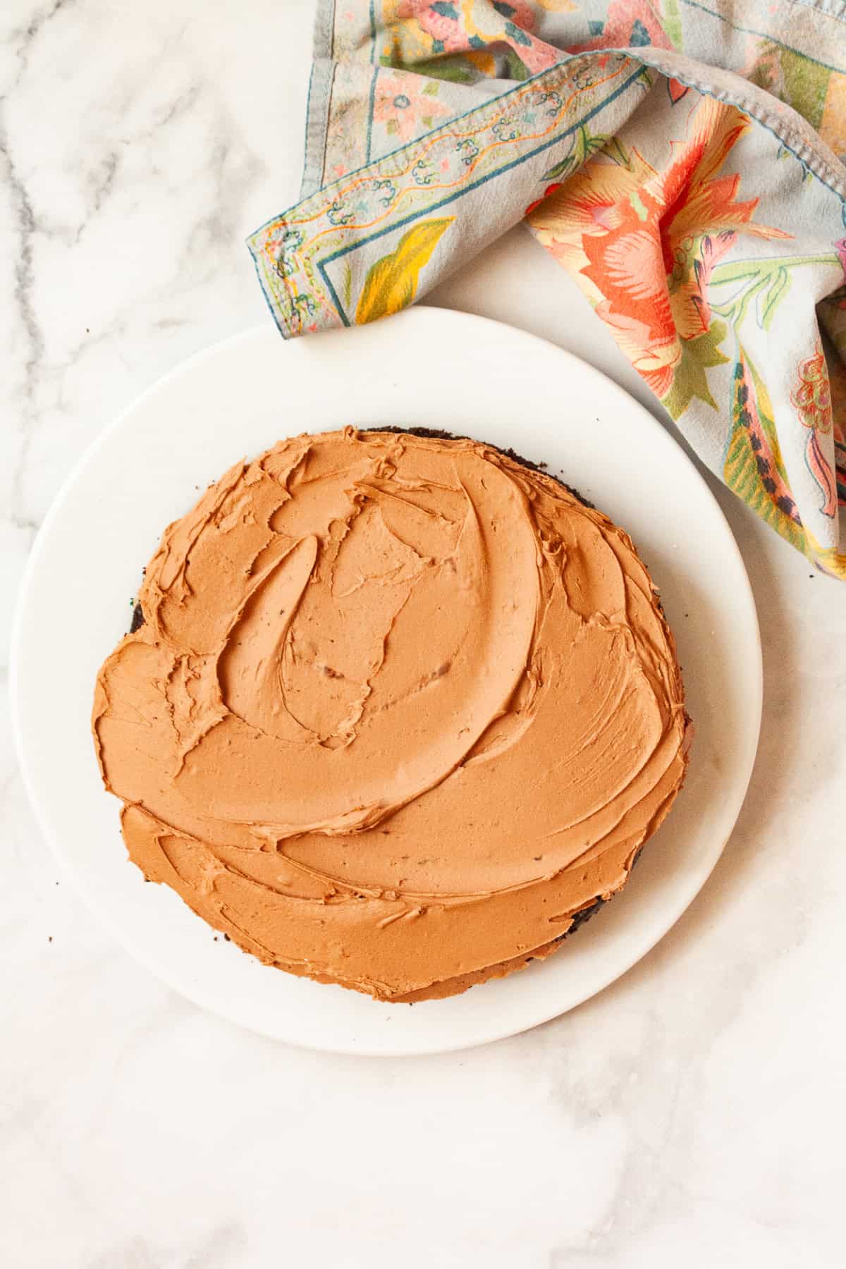 This is the best chocolate cake: Moist, tender, and with a perfect gluten-free crumb! Top it with chocolate buttercream for a real treat. The best chocolate cake ever on a white plate.