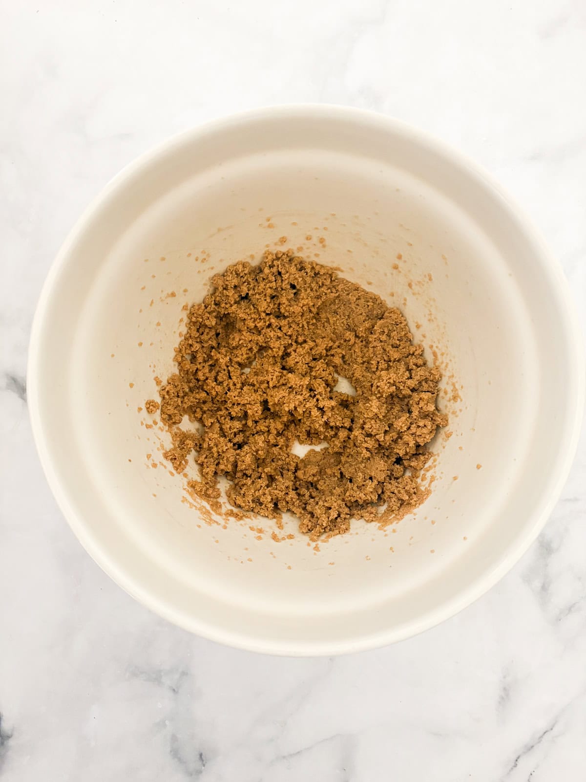 Darkly sweet and studded with walnuts, a gluten free applesauce cake equals homey comfort. Make it with homemade applesauce if you can. Butter and brown sugar creamed in a bowl.