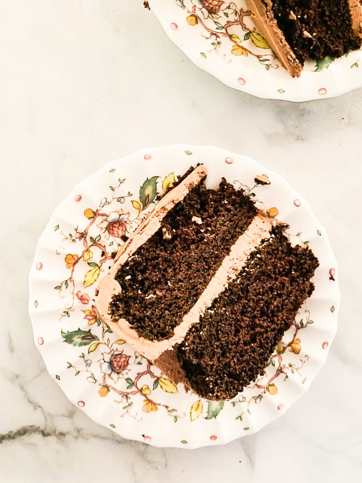 This gluten-free chocolate cake is a deeply dark chocolate cake with a soft and tender crumb that's perfect with fluffy chocolate buttercream. A slice of two-layer gluten-free chocolate cake.